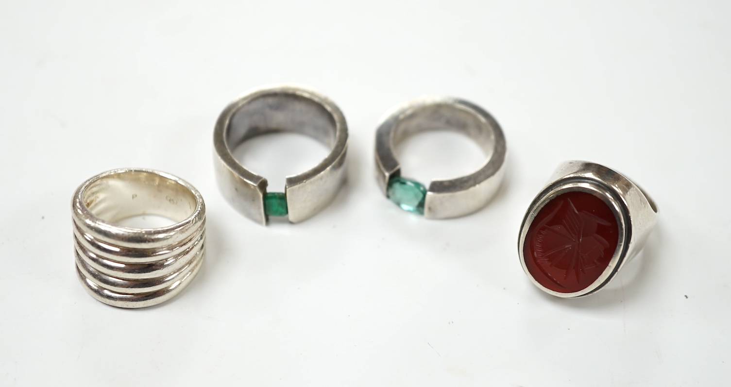Two modern silver rings, one with coiled shank, the other set with intaglio carnelian and two other white metal rings, one set wit an emerald, the other green quartz, maker's mark P&T. Condition - fair